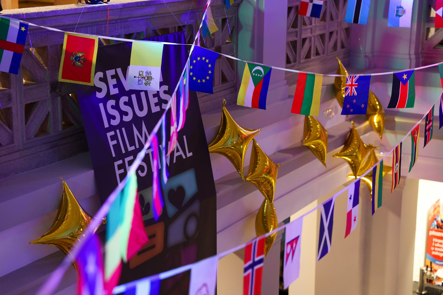 Flags of participating countries and the Seven Issues Film Festival banner in the Edison Cinema foyer.